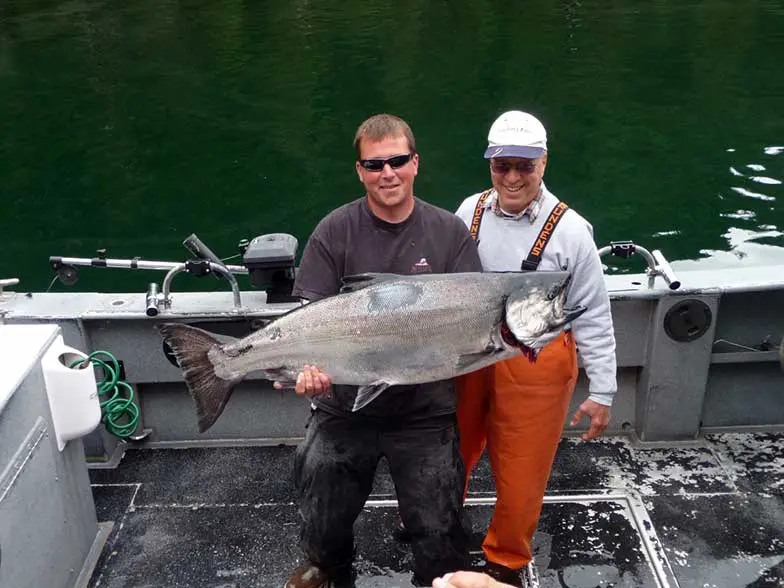 Father & Son Fishing in Alaska - Older son holding up a large fish caught in Alaska